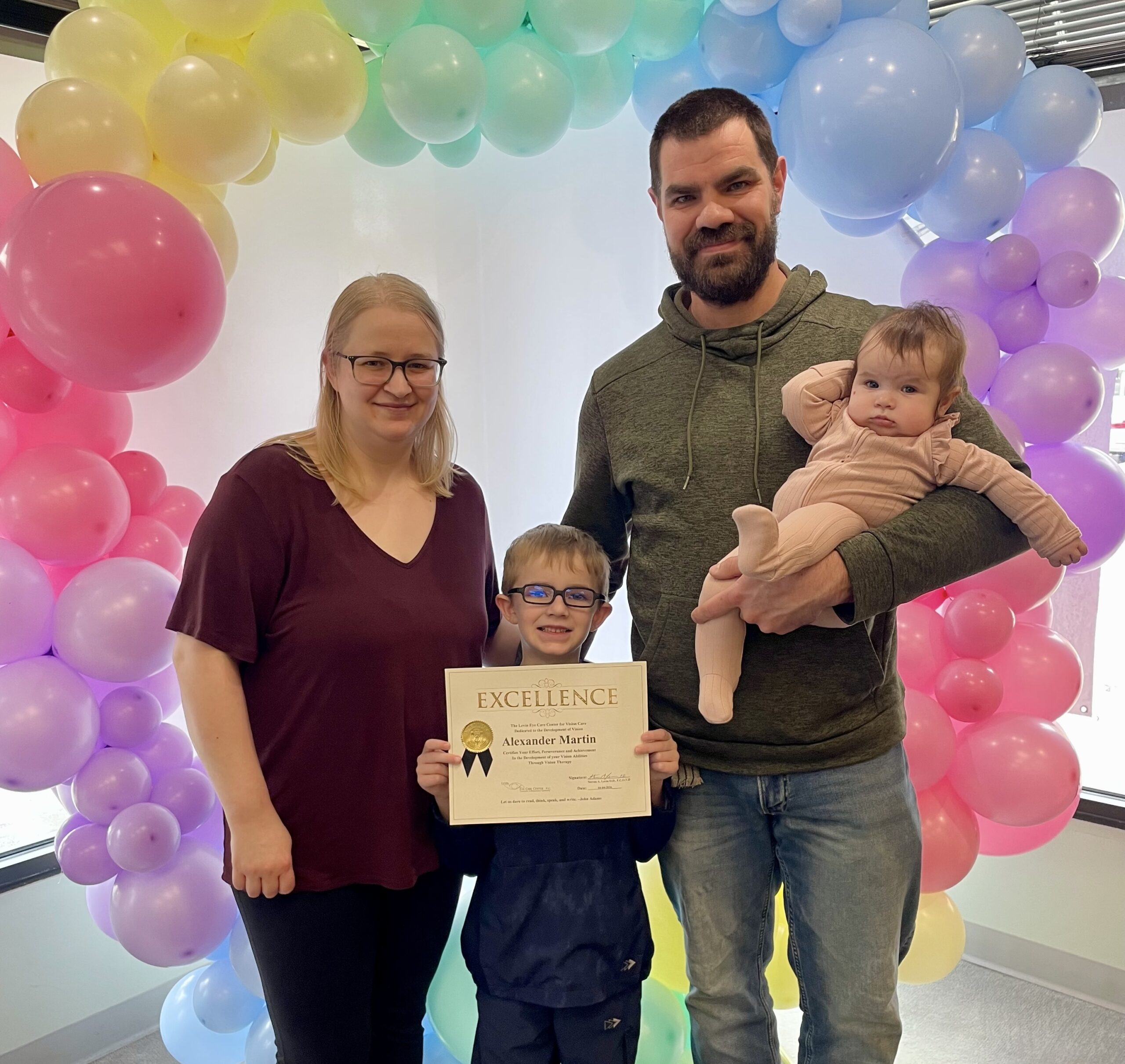 A happy vision therapy graduate celebrating success at Levin Eye Care Center in Northwest Indiana.